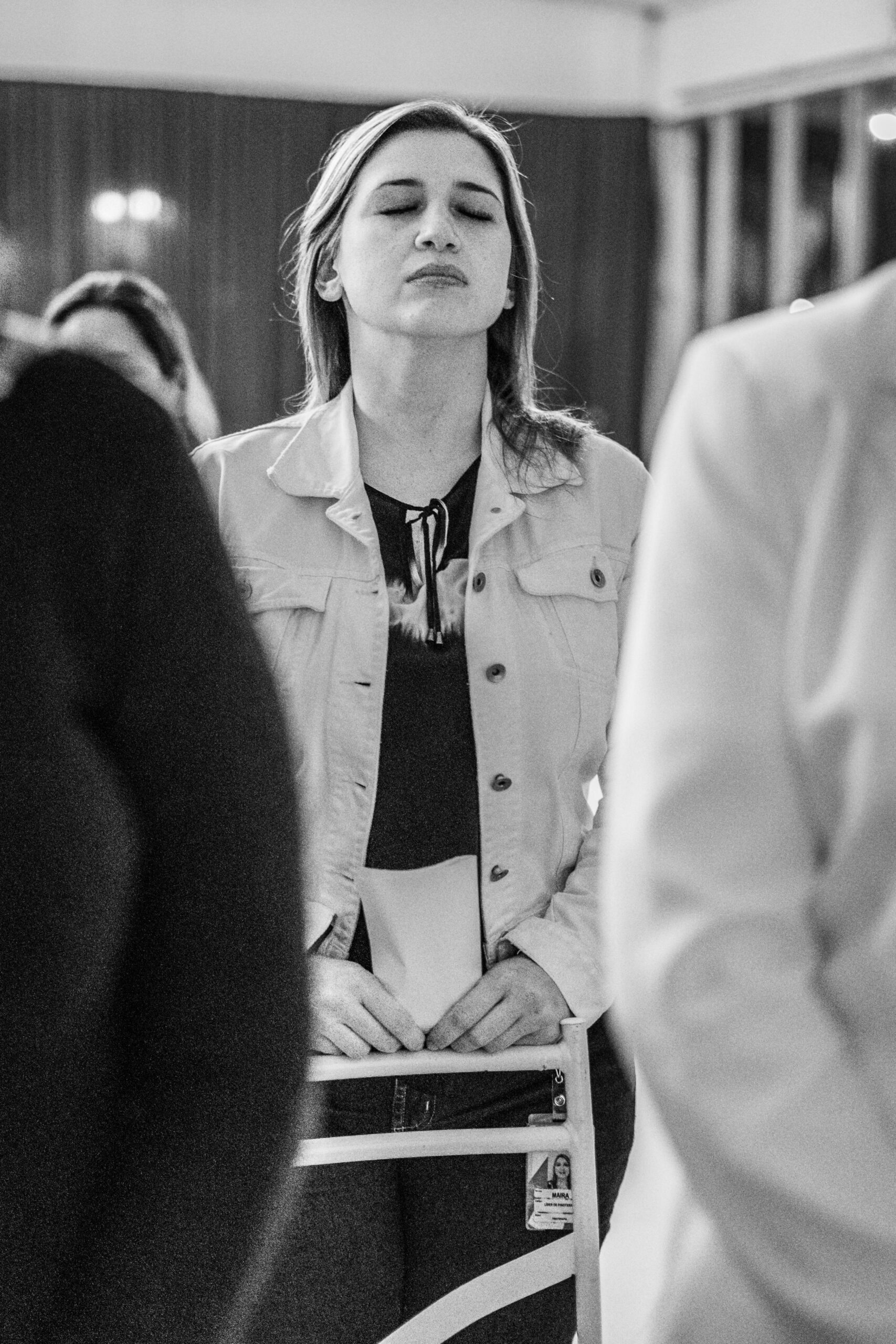 A serene moment of a woman meditating in a workshop setting captured in black and white.